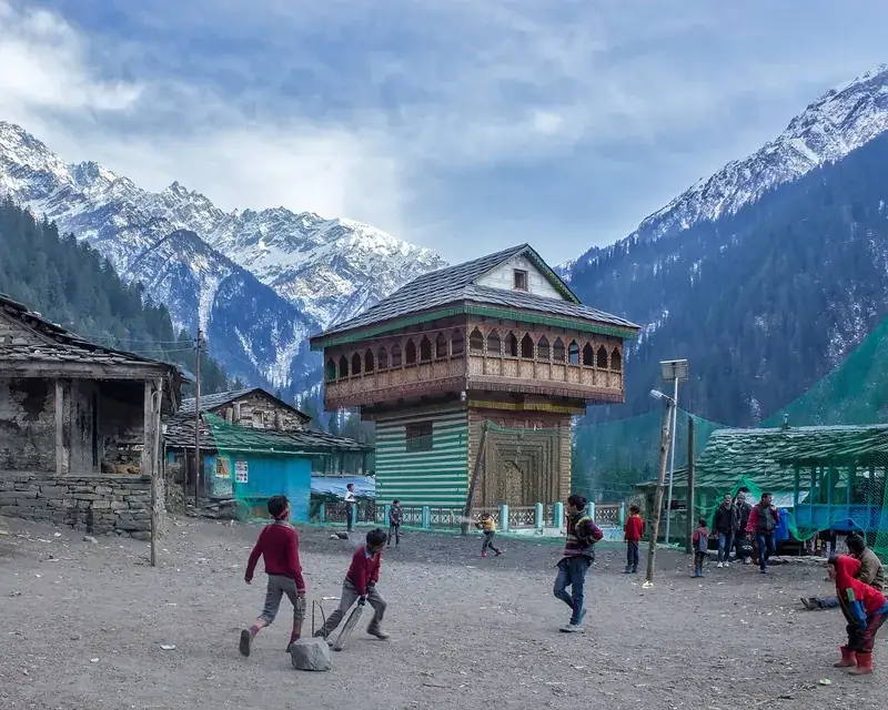 Children playing cricket in a mountain village.
