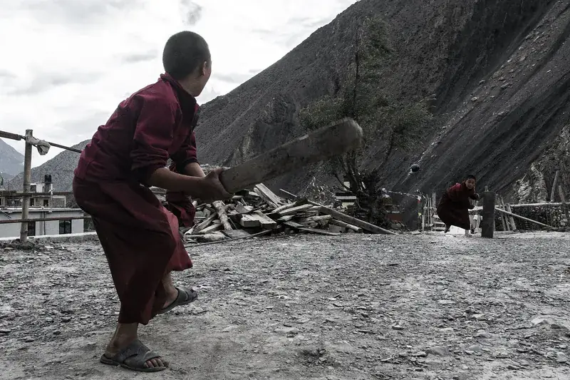 A boy batting in a mountain village.